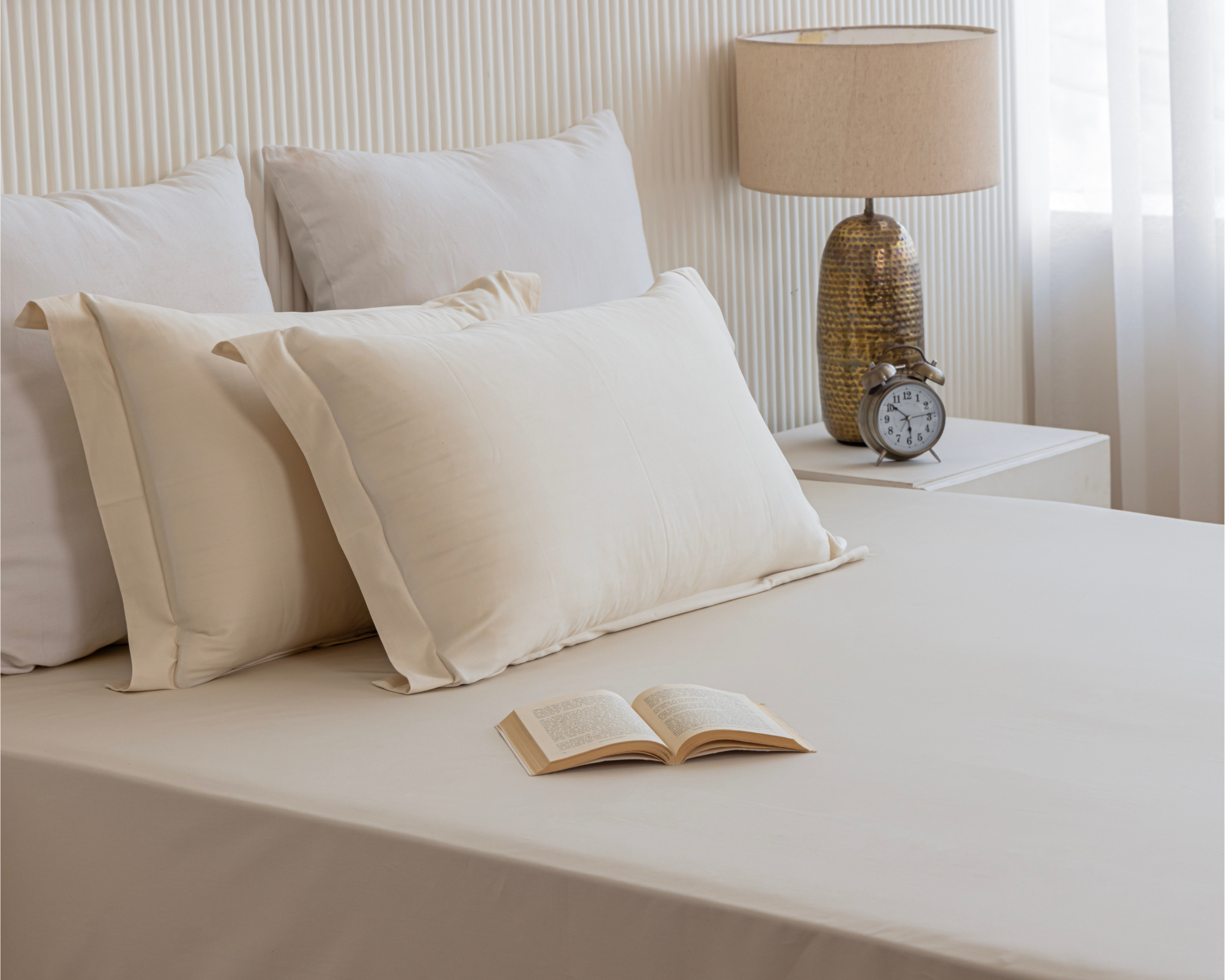Organic cotton flat sheet on bed in neutral tones – Texaura